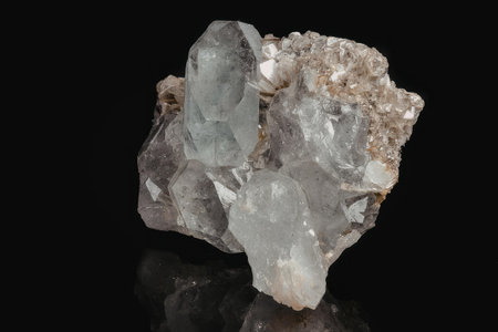 A close-up image of a cluster of quartz crystal with a rough, rocky texture and a predominantly...