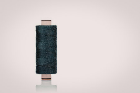 A rolled up green carpet with copper colored metal ends
