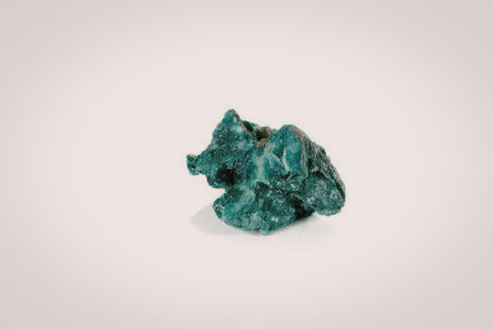 The image shows a green mineral specimen with a rough texture and irregular shape. The mineral has a...
