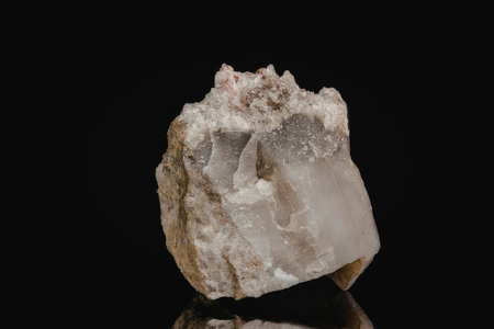A large crystal rock formation with a rough exterior and smooth interior, displayed on a black...