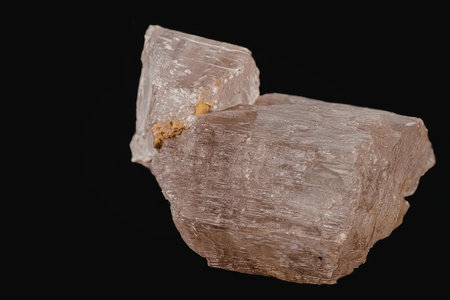 A large crystal rock formation with a rough texture and a small orange inclusion, set against a...
