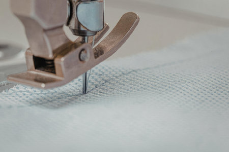 Close-up of a sewing machine's needle stitching through fabric.