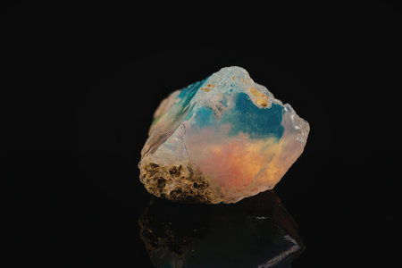 A large, irregularly shaped opal gemstone with a predominantly white base color, exhibiting a...