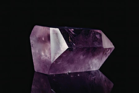 A close-up photograph of a large, vibrant purple amethyst gemstone with a faceted cut, set against a...