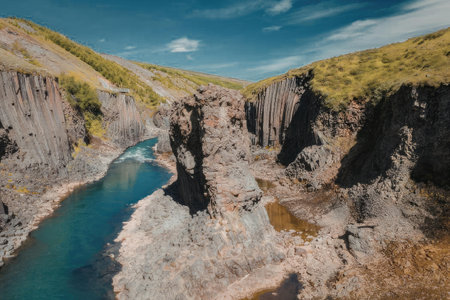 a river flowing through a rocky canyon with steep cliffs and greenery on top