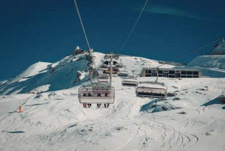 a ski lift on a snowy mountain with a clear blue sky
