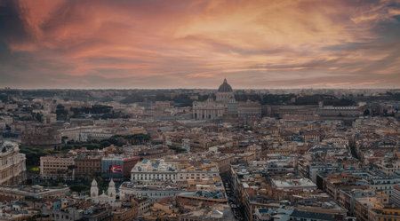 An aerial view of Rome, Italy at sunset, showcasing the city's sprawling landscape and historic architecture under a vibrant orange and pink sky.の写真素材
