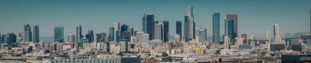 A panoramic view of a city skyline with numerous skyscrapers and buildings under a clear blue sky.