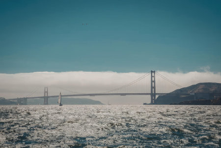 The Golden Gate Bridge stands tall amidst fog and water, showcasing its iconic suspension design...