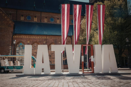 A large white sign with the word 'LATVIA' in bold letters, accompanied by red and white striped...