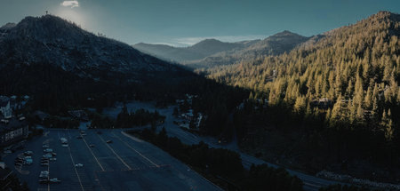 aerial view of a parking lot surrounded by mountains and trees