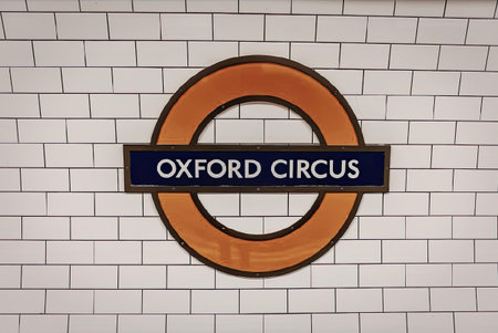 A red circle with a blue rectangle in the middle, on a white brick wall background, displaying the...