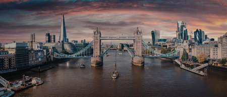 A panoramic view of Tower Bridge in London, England, at sunset, showcasing the bridge's towers and...