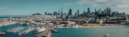 A panoramic view of a city skyline with a large body of water in the foreground. The city has many...