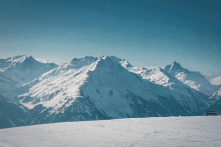A breathtaking view of a snow-covered mountain range under a clear blue sky.