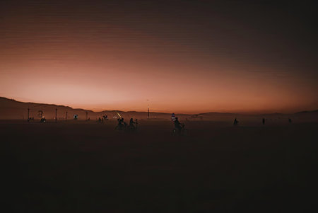 A serene landscape of a sunset with a dark foreground and vibrant orange sky.の写真素材