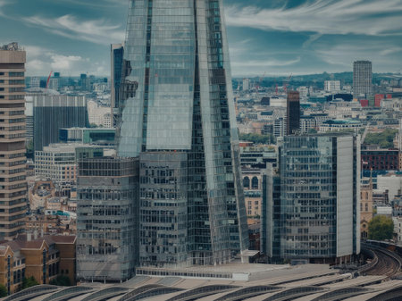 A tall glass skyscraper stands prominently in the heart of London, surrounded by other buildings and cityscape.の写真素材