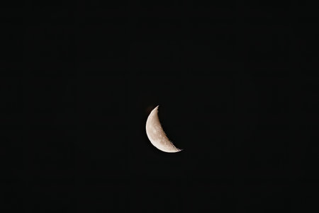 The image captures a serene moment of the moon in its crescent phase, glowing softly against the...
