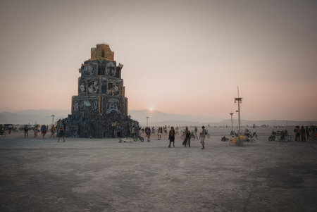 A large structure at sunset with people around it