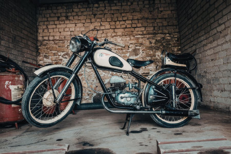 A vintage motorcycle parked in a garage with a brick wall background