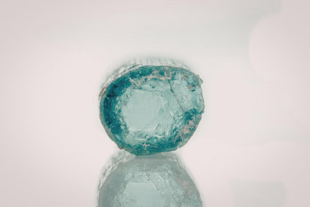 A large, rough-cut gemstone with a predominantly green color and inclusions, set against a white background.の写真素材