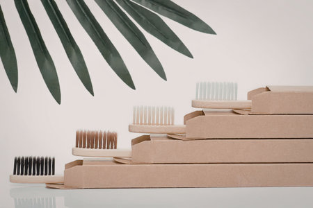 A stack of eco-friendly bamboo toothbrushes with different colored bristles