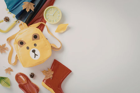 A collection of autumn-themed school supplies and toys, including a yellow backpack, red boots, and fall leaves.の写真素材