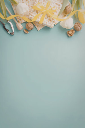Easter decoration with matzo, flowers, nuts, and yellow ribbon on a light blue background.