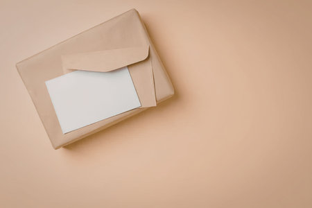 A brown envelope with a blank white card inside on an orange background