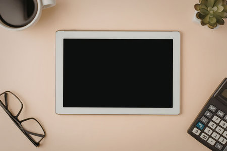 A tablet surrounded by office accessories on a desk