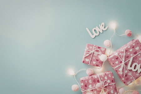 A visually appealing arrangement of pink gifts, love decorations, and fairy lights on a blue...