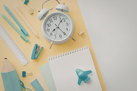 A collection of school supplies, including pencils, a ruler, and a notebook, alongside an alarm...