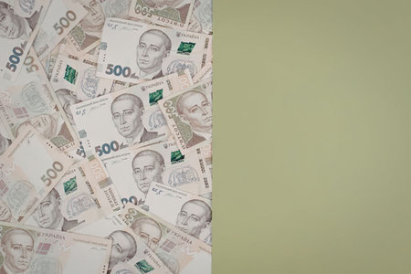 A stack of 500 banknotes with a portrait of a man on them, arranged on a white and green backgroundの写真素材