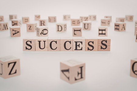 The image features wooden blocks with letters arranged to spell out 'SUCCESS' with other blocks...