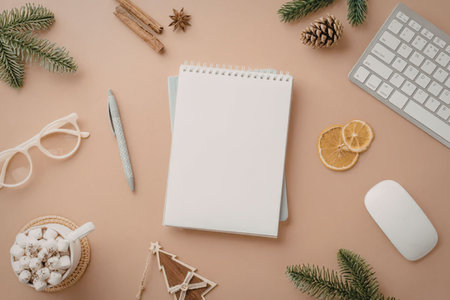 A winter-themed workspace setup with a notebook, computer keyboard, mouse, and festive decorations.