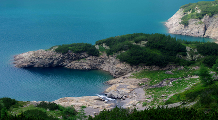 Mountain landscape with a blue lake, white cliffs and pines - Italian Alps