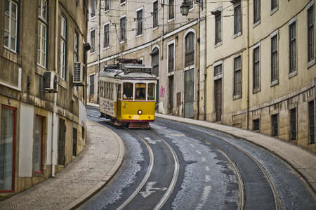 Lisbon, Portugal, April 24th 2012  A typical Lisbon yellow tram descends slowly down the curvy between Bairo Alto and the Rossio area  This is the tram number 28, the one that people use as touristic tram のeditorial素材