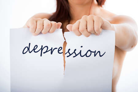 woman tearing sheet of paper with the word depressionの写真素材