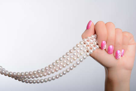 cultured pearls presented with nails painted pinkの写真素材