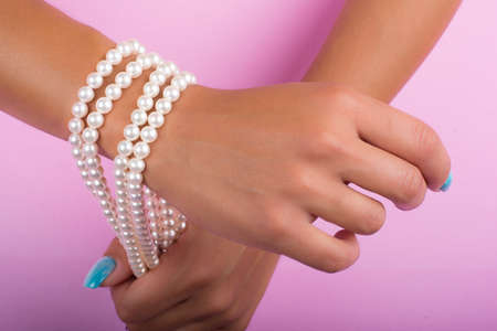 hands with painted nails and pearlsの写真素材