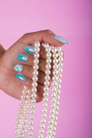 hands with painted nails and pearlsの写真素材