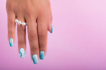 hands with painted nails and pearlsの写真素材