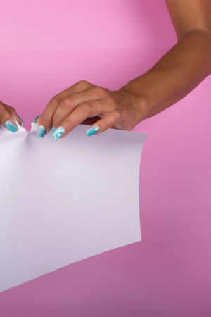 hands with painted nails that hold white sheetの写真素材