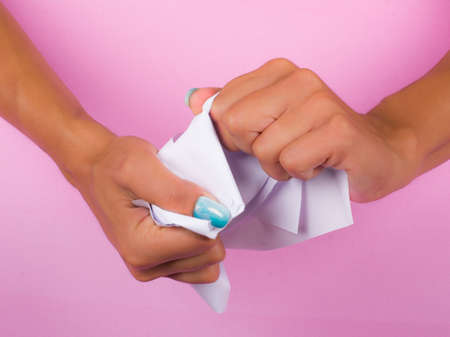 hands with painted nails that hold white sheetの写真素材