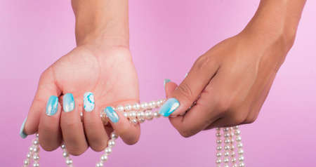 hands with painted nails and pearlsの写真素材
