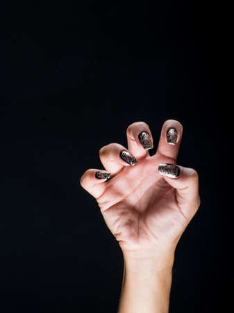 hands of witch with nails painted with dark colorsの写真素材