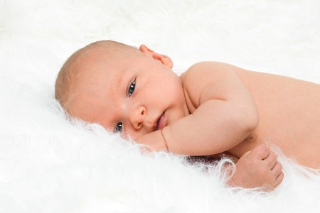 Newborn cute baby boy lying on fur blanketの写真素材