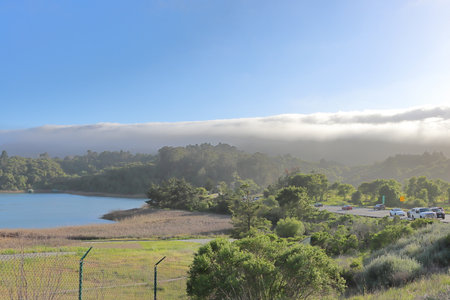 Landscape view of a lake in the morning with fog and clouds