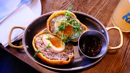 Breakfast with coffee and eggs in a basket on a wooden tableの写真素材