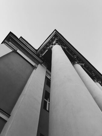 The corners of the columns of a tall building directed into the sky in black and white color.の写真素材